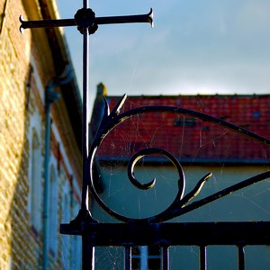 Croix en métal sur une porte en fer forgé et toiles d'araignées - Belgique  - collection de photos clin d'oeil, catégorie clindoeil